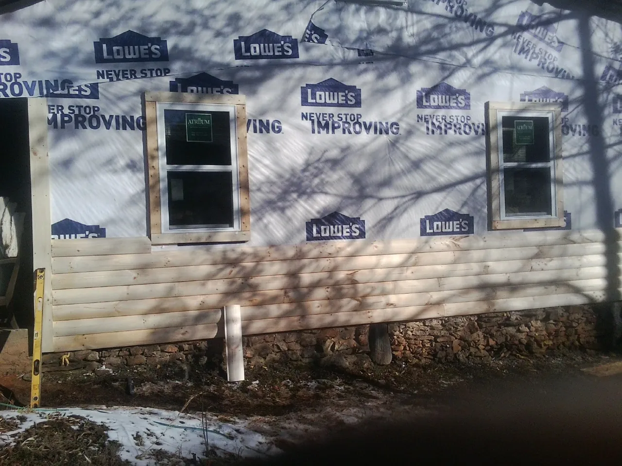 House wrap and new log siding going up on an exterior wall in Florham Park