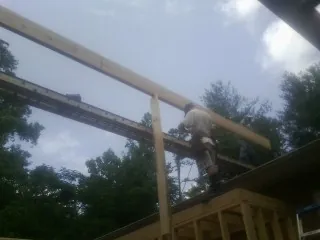 Carpenter setting a ridge beam over a new addition frame — Ice Dam Removal by Roofing Brothers in Florham Park
