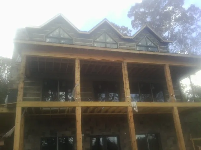 Dormers and porch framing on a large log home under construction — Roof Coating work by our crew in Florham Park