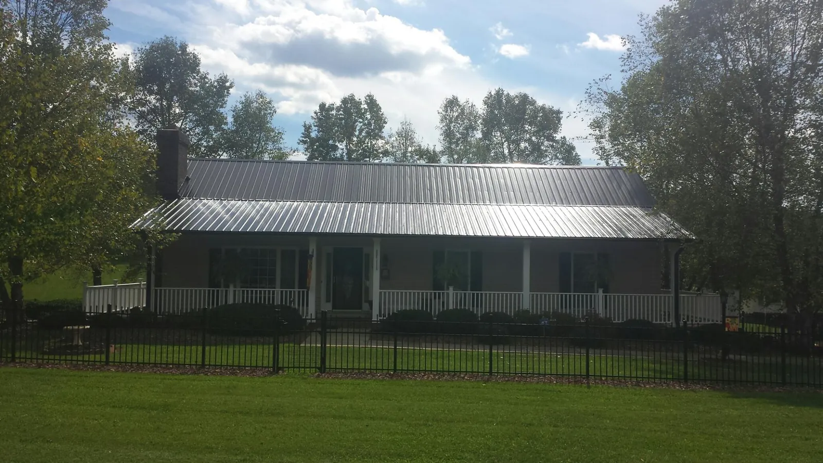 Gray metal roof on a brick ranch with a full width front porch — Gutter Guard Installation work by our crew in Florham Park
